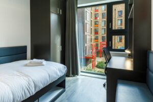 Contemporary university student room with single bed and built-in storage